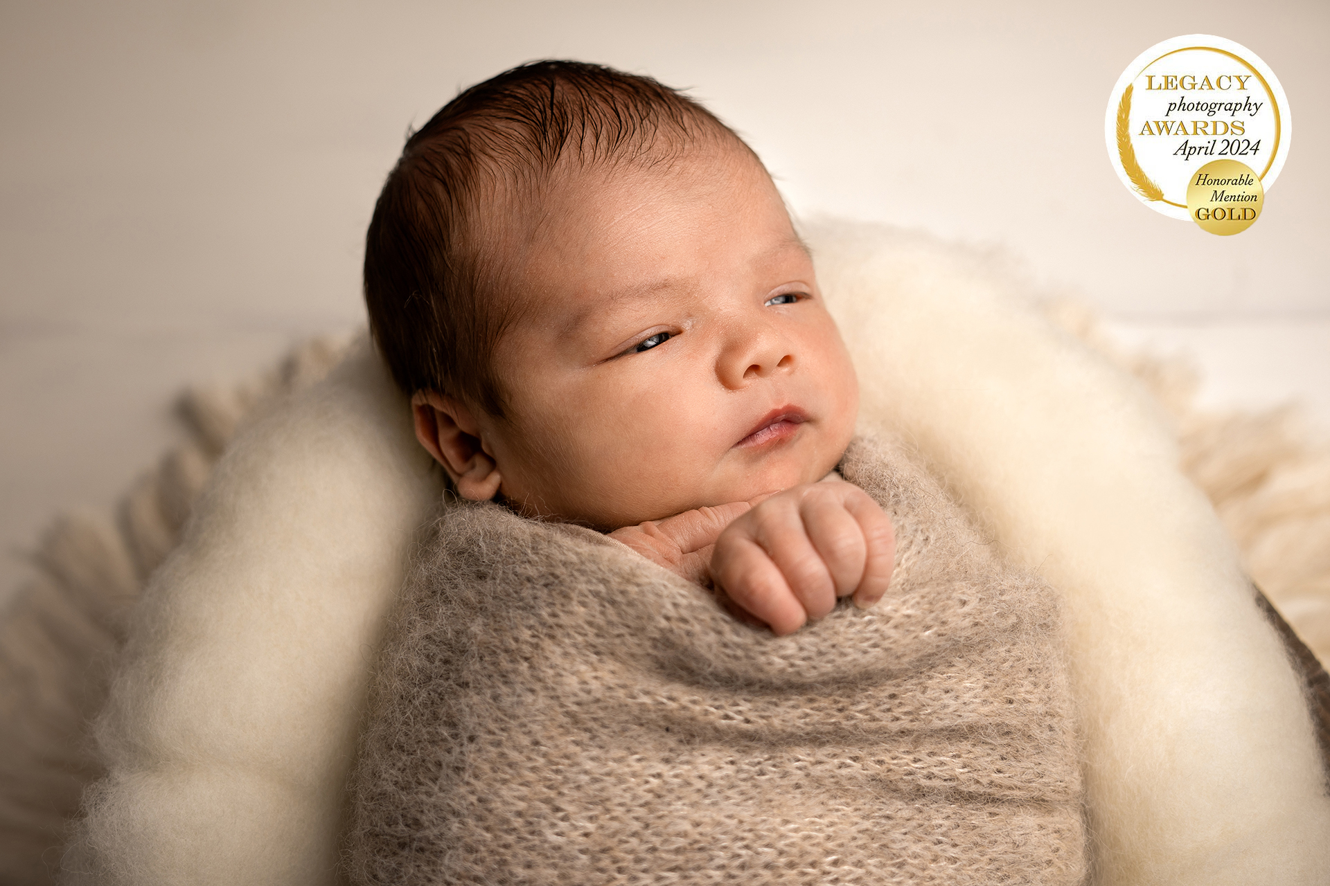 Séance photo naissance réalisée au home studio - nouveau-né emmailloté avec les yeux ouverts