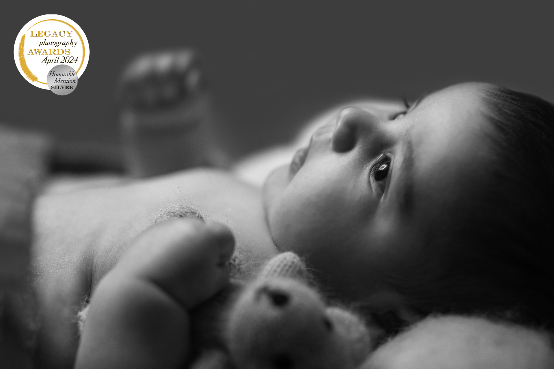Séance photo en noir et blanc de bébé avec petite nounours au home studio